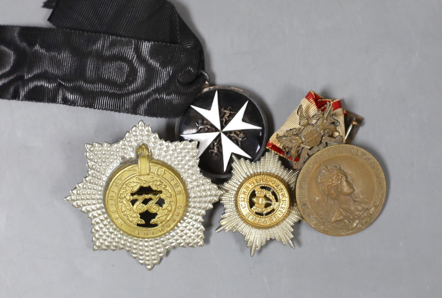 An Edwardian ‘Fear God Honour the King’ medal, ‘The Cheshire Regiment’ badge, and two other medals and badge (4)